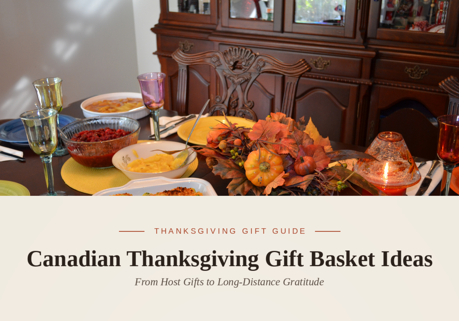 A festive Thanksgiving table centerpiece with miniature pumpkins, fall leaves, glassware, and dishes of food.
