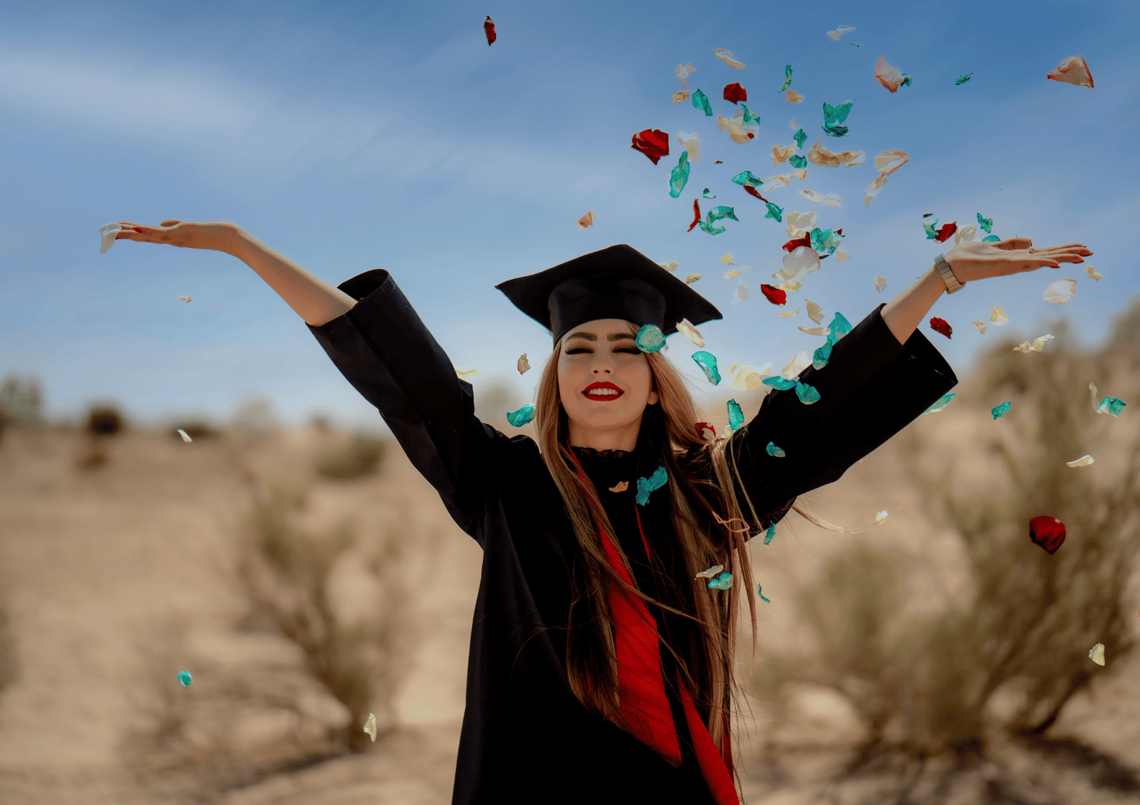 Last-Minute Graduation Gifts: A happy graduate throwing confetti in the air while wearing a black cap and gown.