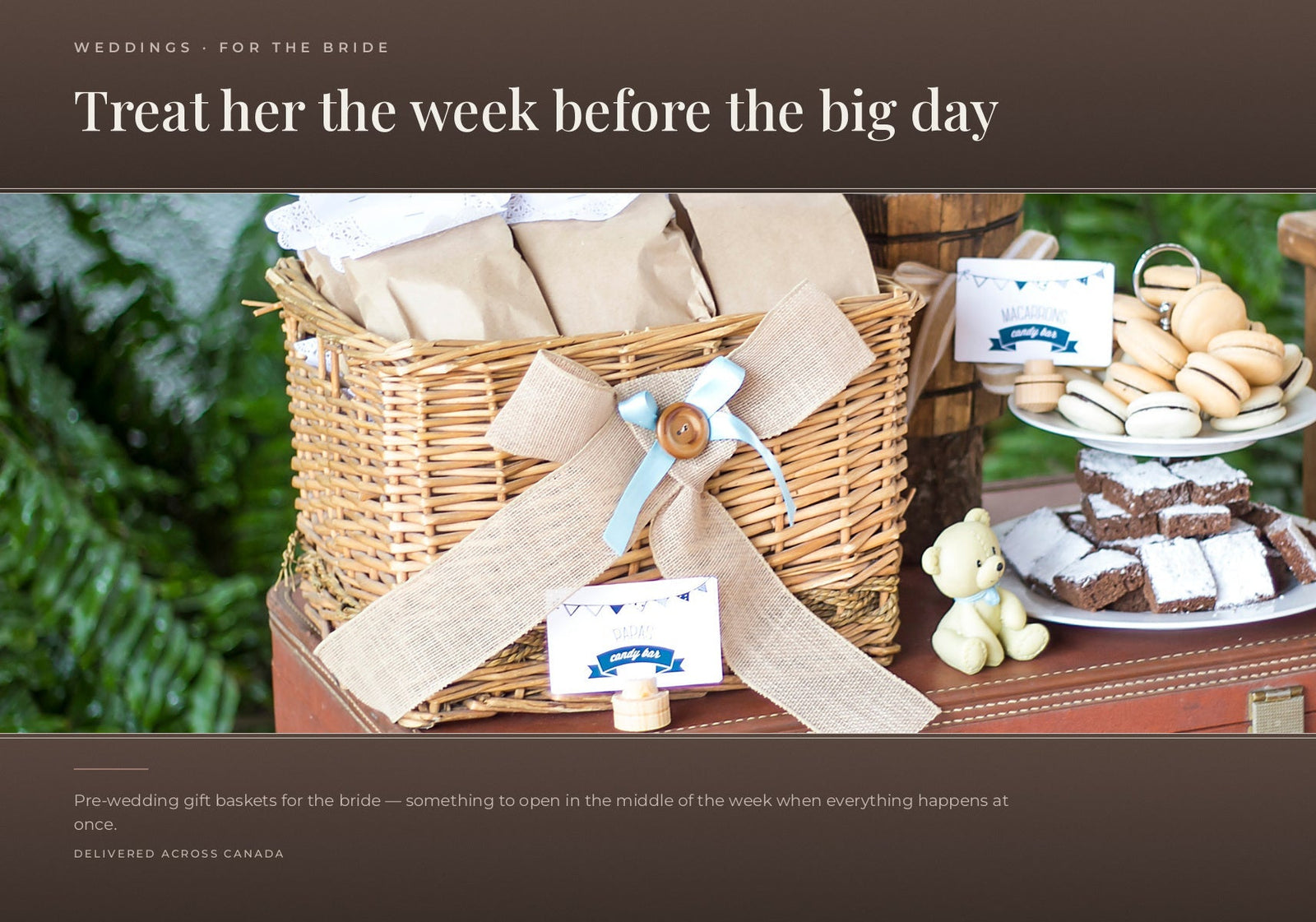 A wicker gift basket with a burlap bow alongside treats including macarons and brownies.