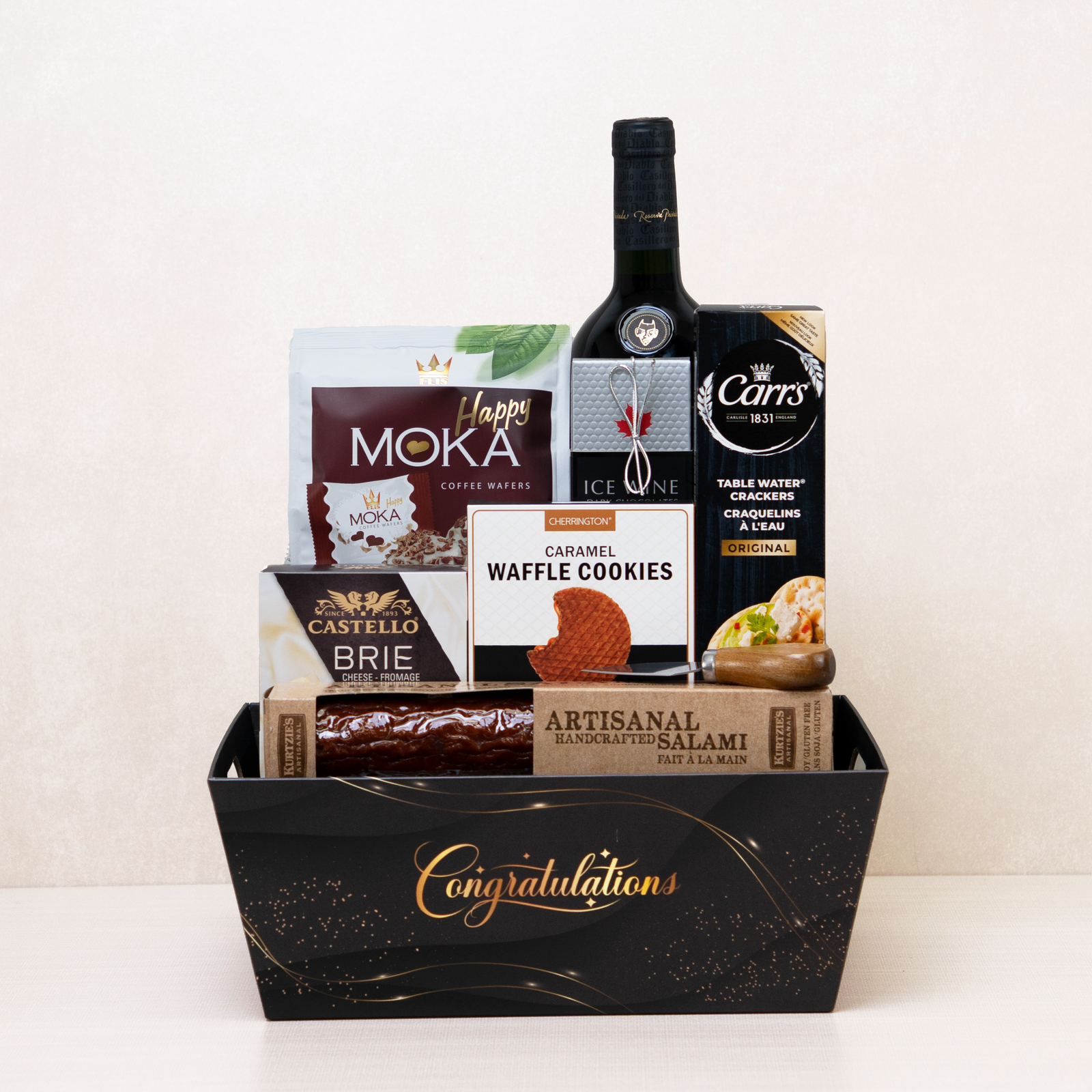Gourmet Congratulations Gift Basket with red wine, brie cheese, artisanal salami, chocolates, crackers, and cookies.