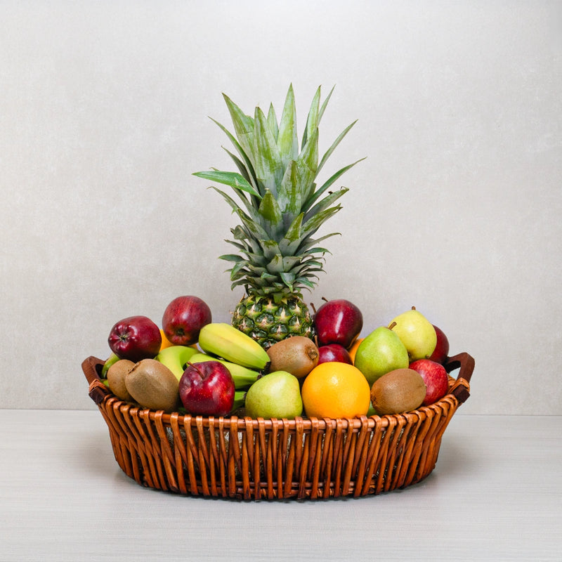 A fresh fruit basket with pineapple, apples, kiwi and pears