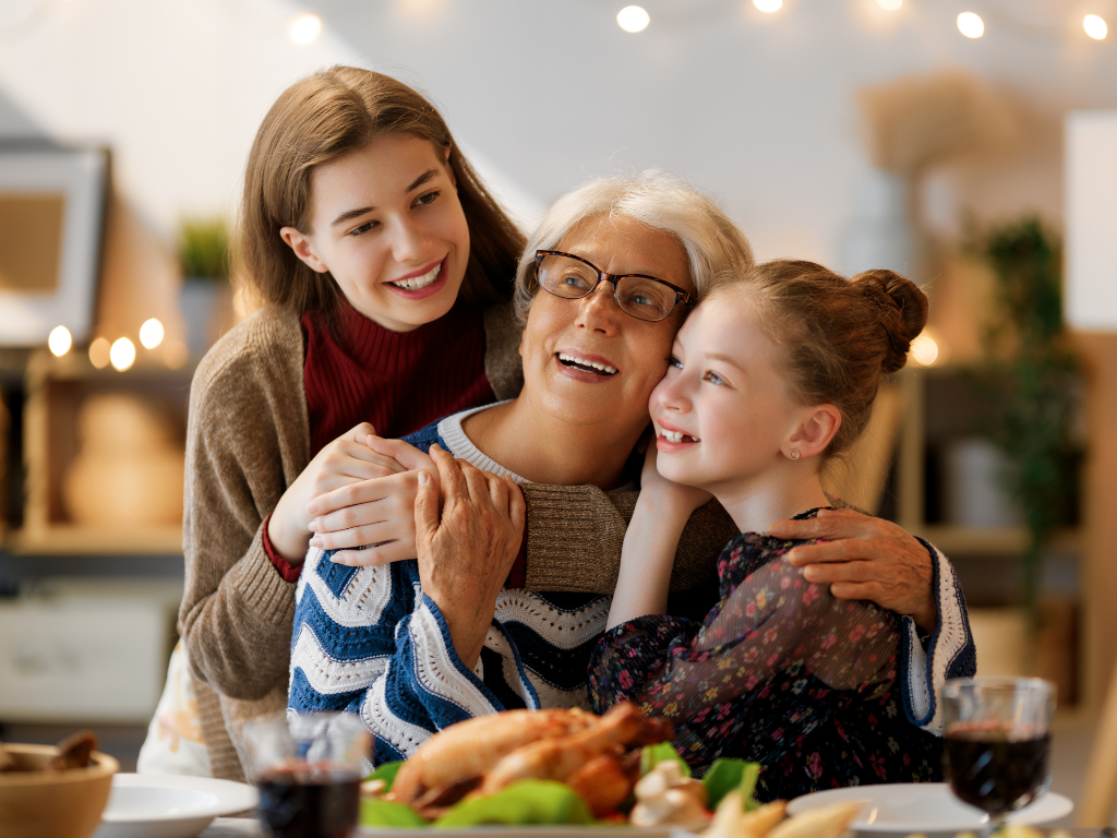 A grandmother, daughter, and granddaughter celebrating Mother’s Day 2026 with a festive home-cooked meal.