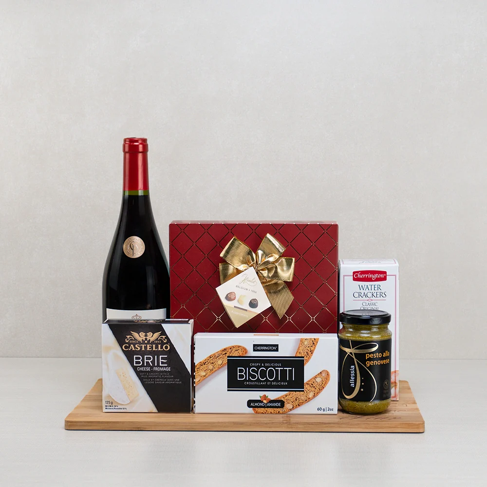 A Gourmet Gifts basket with Belgian chocolates, brie and gourmet snacks styled for holiday gifting