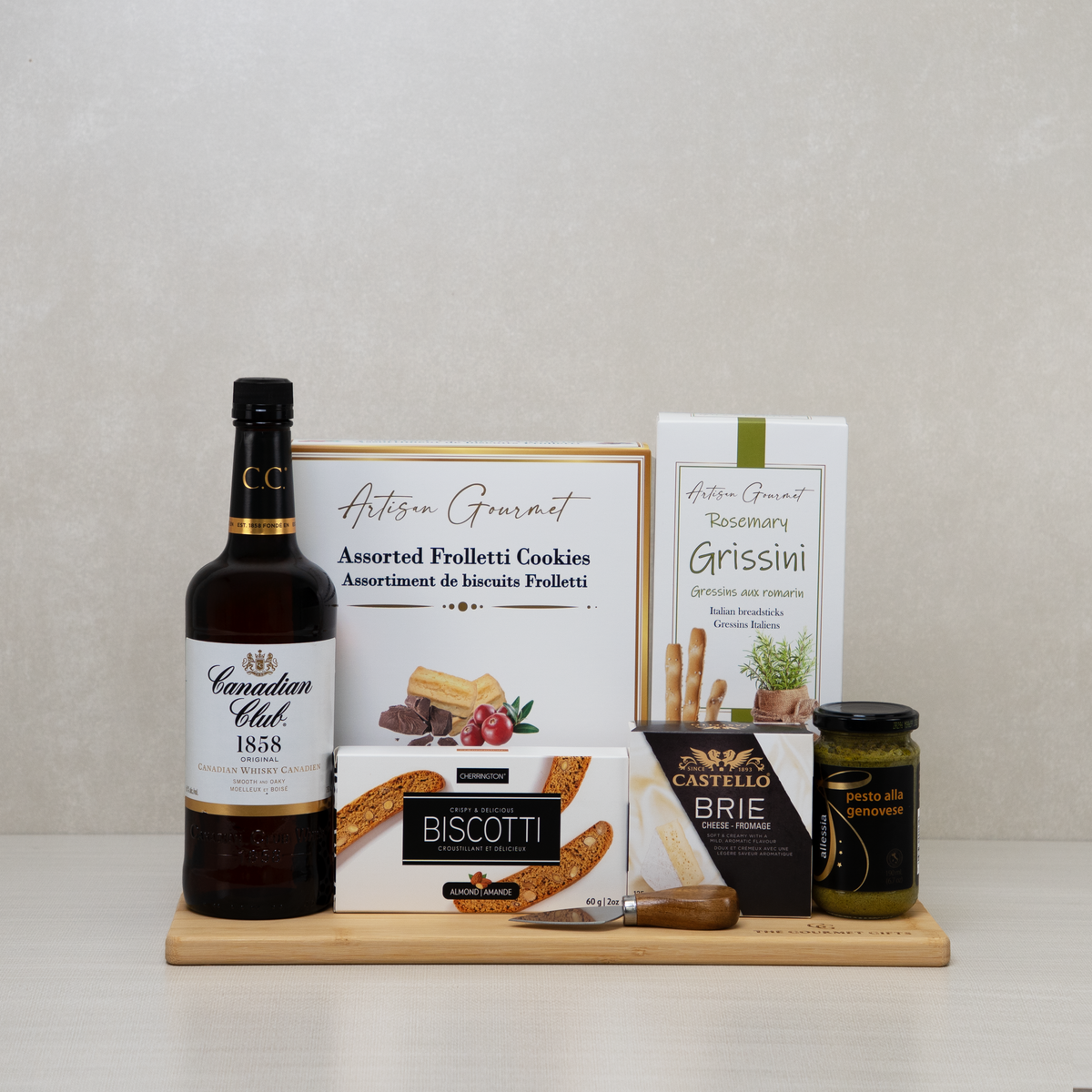 Canadian Whisky Lover's Basket with Canadian whisky, brie, biscotti, pesto, breadsticks, and cookies.