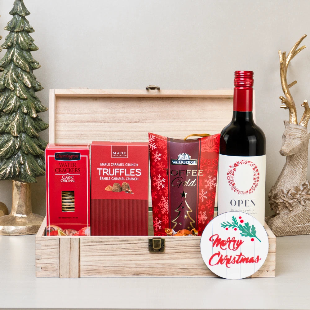 Holiday wine gift set with caramel candy, water crackers, and maple caramel truffles in a rustic wooden box.