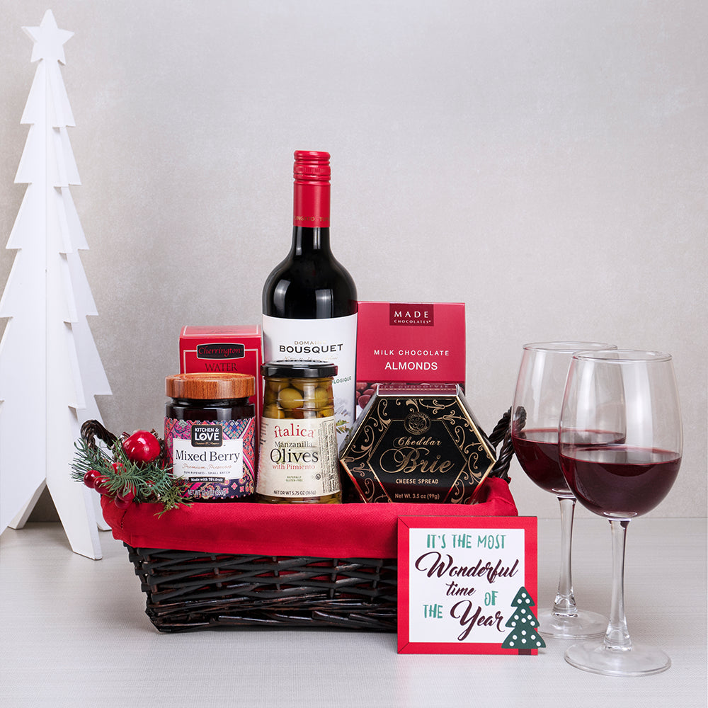 Holiday Harmony Wine & Treats Basket with Domaine Bousquet red wine, cheddar brie spread and olives in a red-lined basket