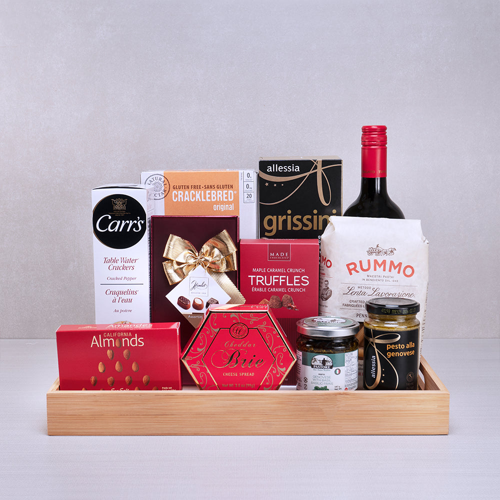 Italian Gourmet Celebration Basket with red wine, Rummo penne, Allessia grissini, pesto and maple truffles on a bamboo tray