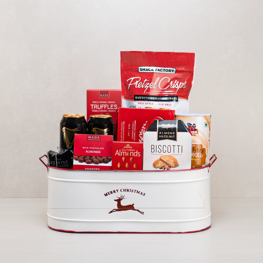 Merry Christmas Gift Goodies Basket with two Guinness cans, pretzel crisps, Lindt Lindor and biscotti in a white reindeer tub