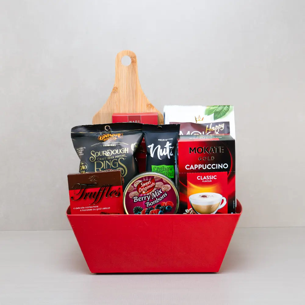 The Cozy Corner Snack Basket in red with craft beer pretzel rings, berry bonbons, Mokate cappuccino and a bamboo board