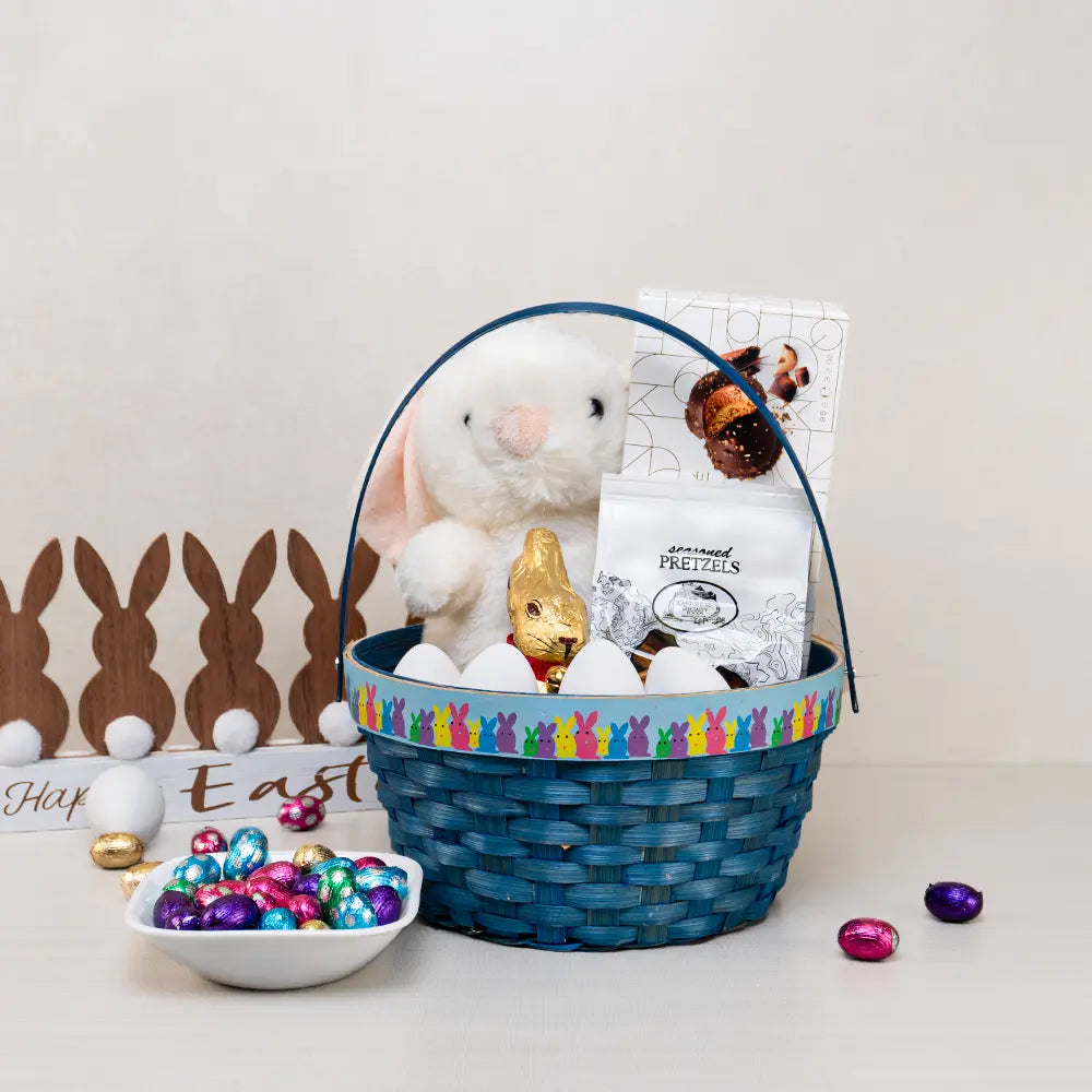 Baby Boy Easter Gift Basket in blue weave with a white plush bunny, gold foil chocolate bunny, plastic eggs and pretzels
