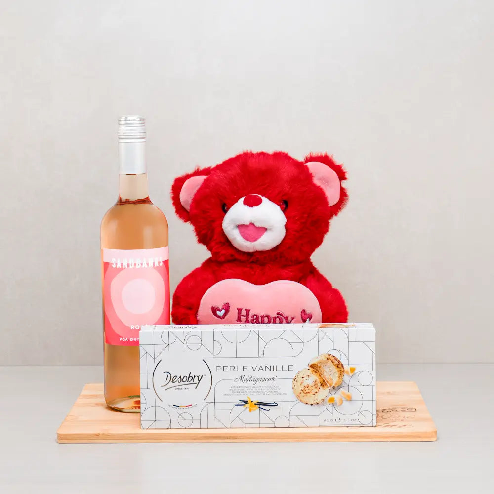 Blush of Love Gift Basket with Sandbanks rosé, a red teddy bear hugging a pink heart and Desobry vanilla cookies on a board