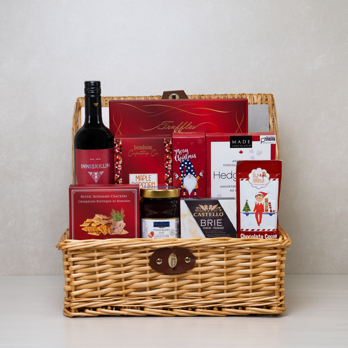 Festive Flavours Gourmet Gift Basket with red wine, brie cheese, chocolates, crackers, popcorn, and gourmet treats.