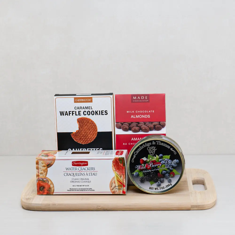 Flavours of Calm gift basket with caramel waffle cookies, milk chocolate almonds, wild berry drops and crackers on a board