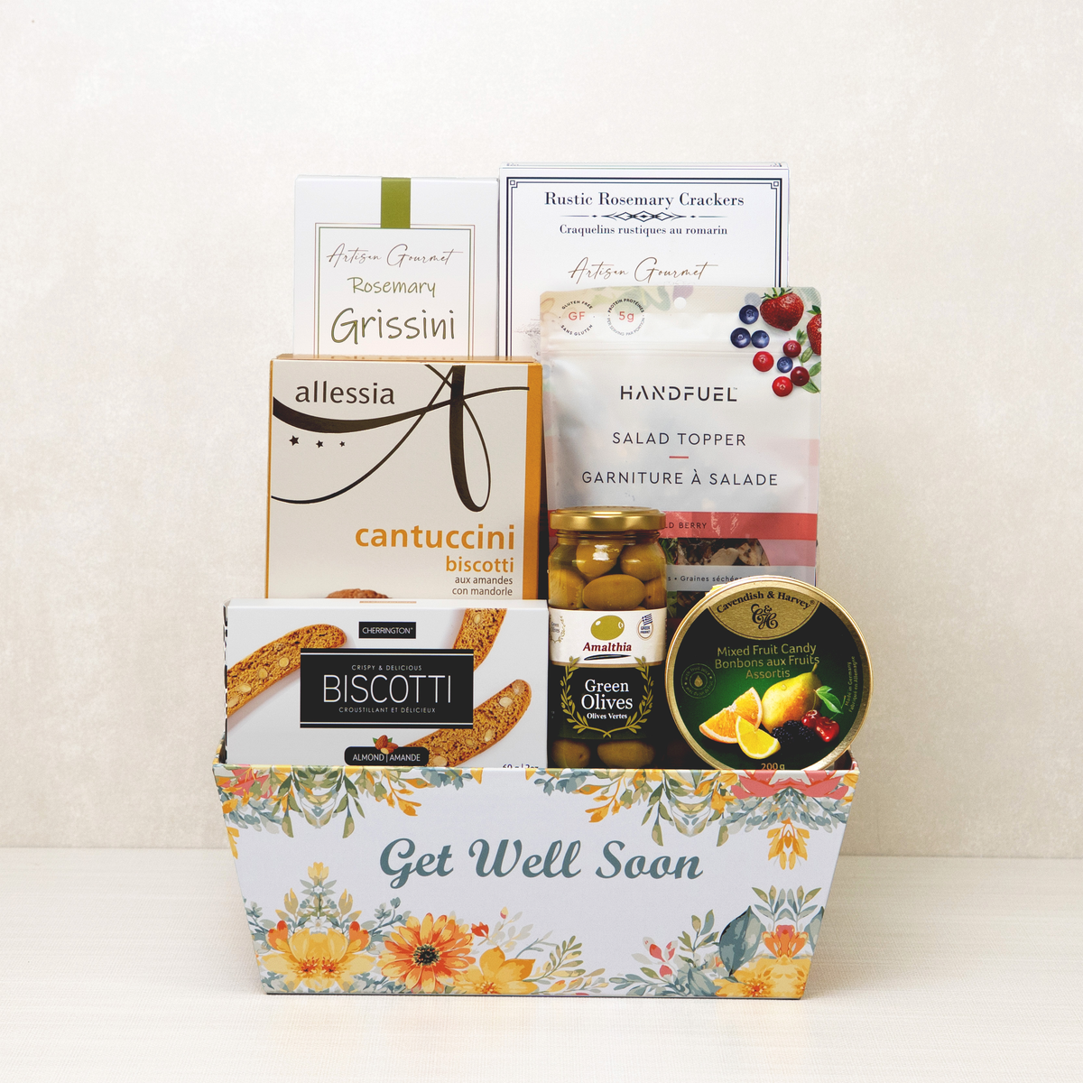 Get Well Goodies Basket printed with flowers and Get Well Soon, holding biscotti, rosemary grissini, olives and fruit candy