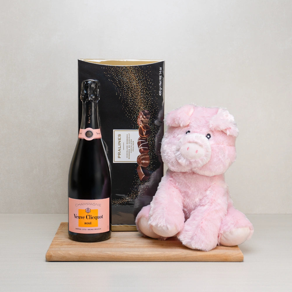 Champagne & Praline Delight gift set with Veuve Clicquot Rosé, a box of Belgian pralines and a pink plush pig on a board