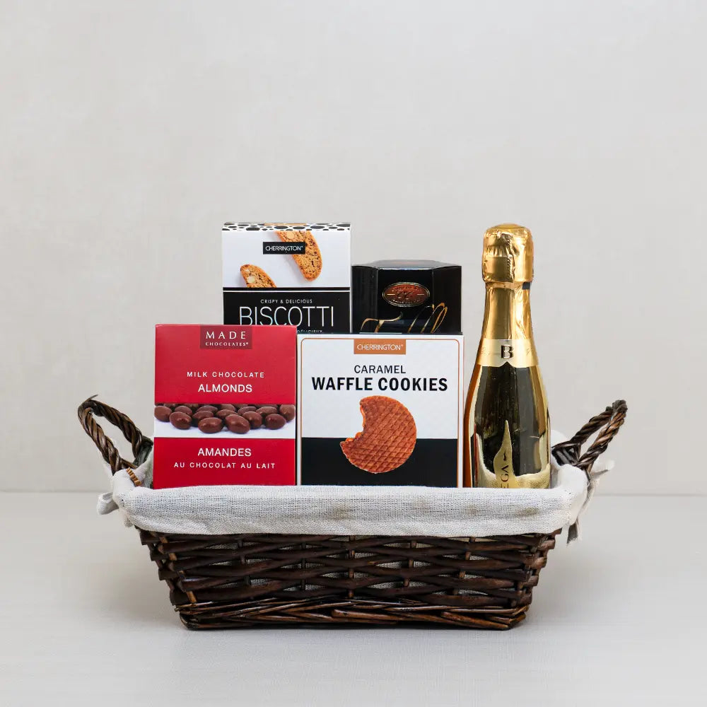 Toast to Love wicker gift basket with mini sparkling wine in a gold bottle, chocolate almonds, biscotti and waffle cookies