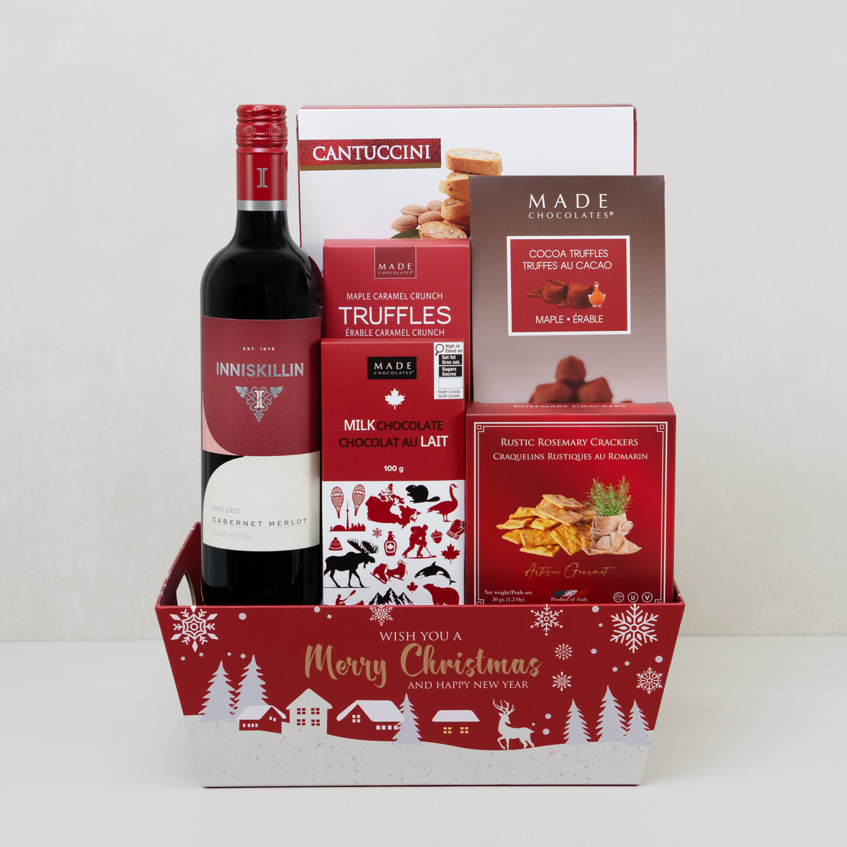 Merry Christmas Cheers Basket with red wine, rosemary crackers, maple truffles, and a chocolate bar in a red festive basket.