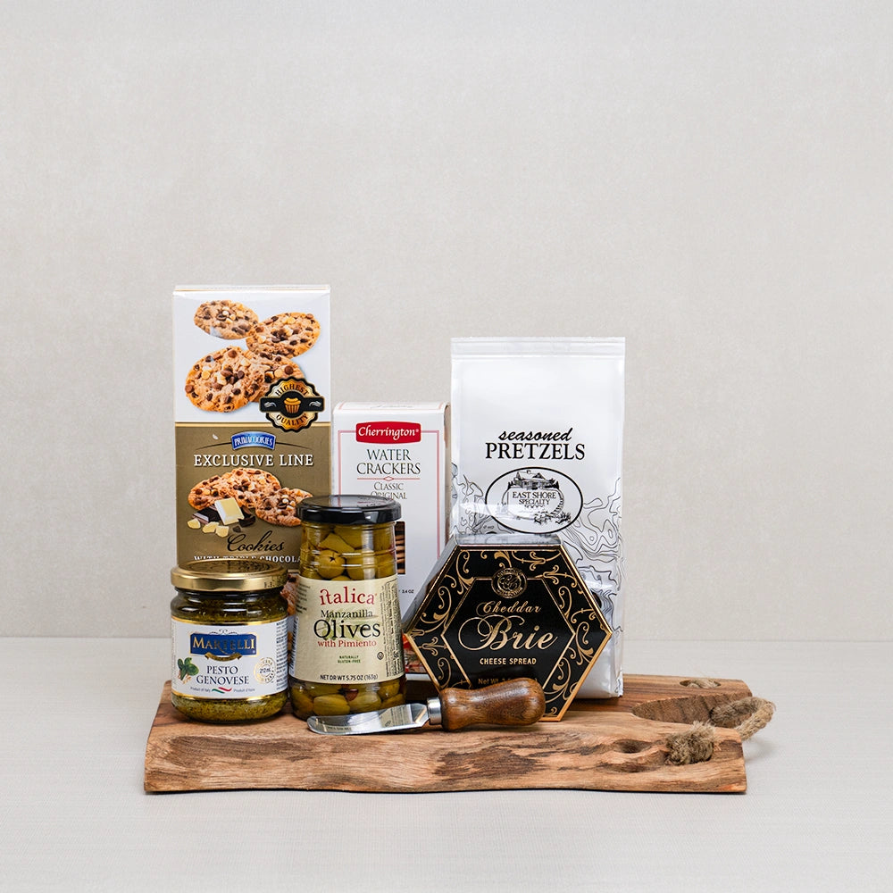 Cheese, Crackers & Cookie Delight gift set with cheddar brie spread, olives, pesto and chocolate cookies on a live edge board