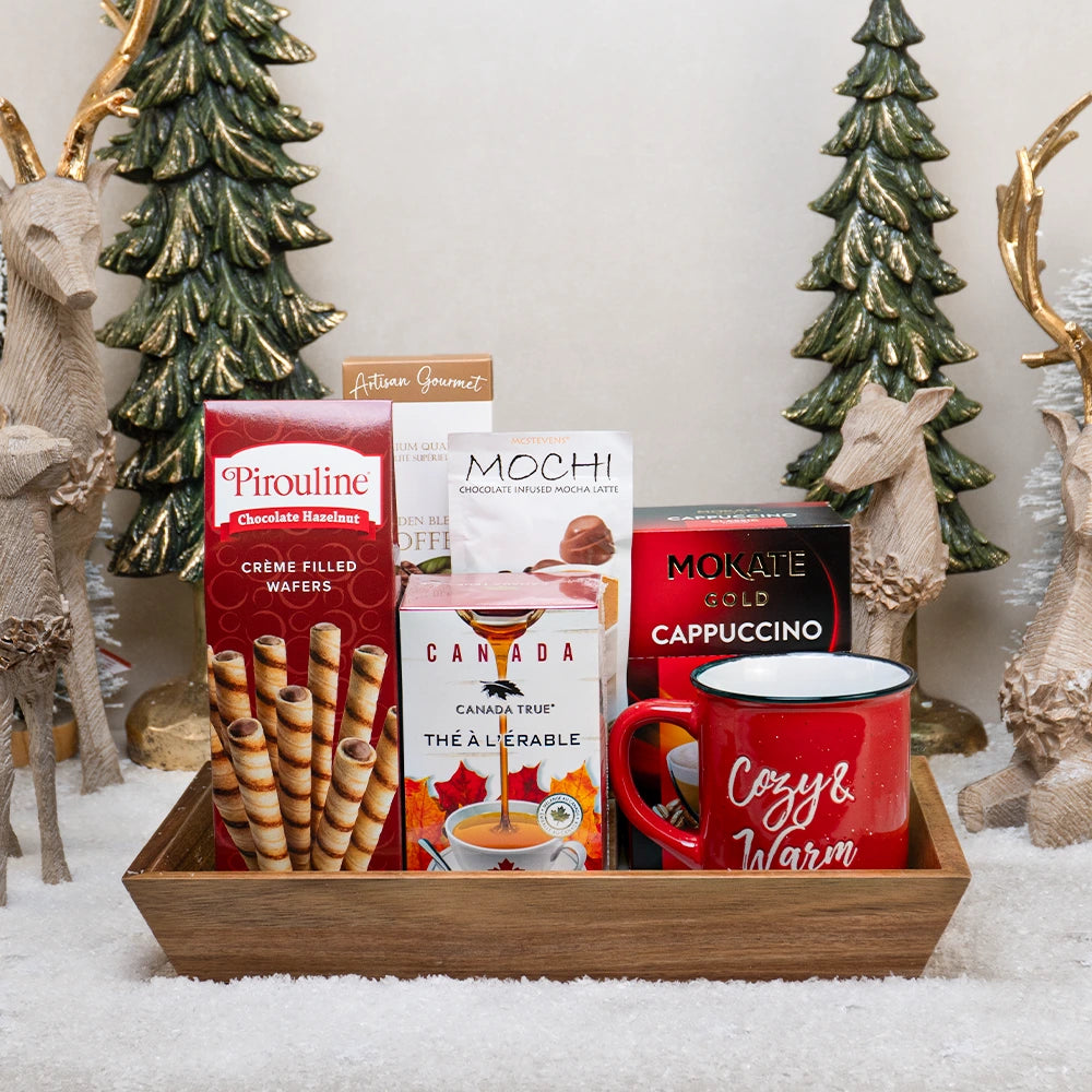 Gift basket with coffee, cookies, and a mug in a festive setting with Christmas trees and deer.