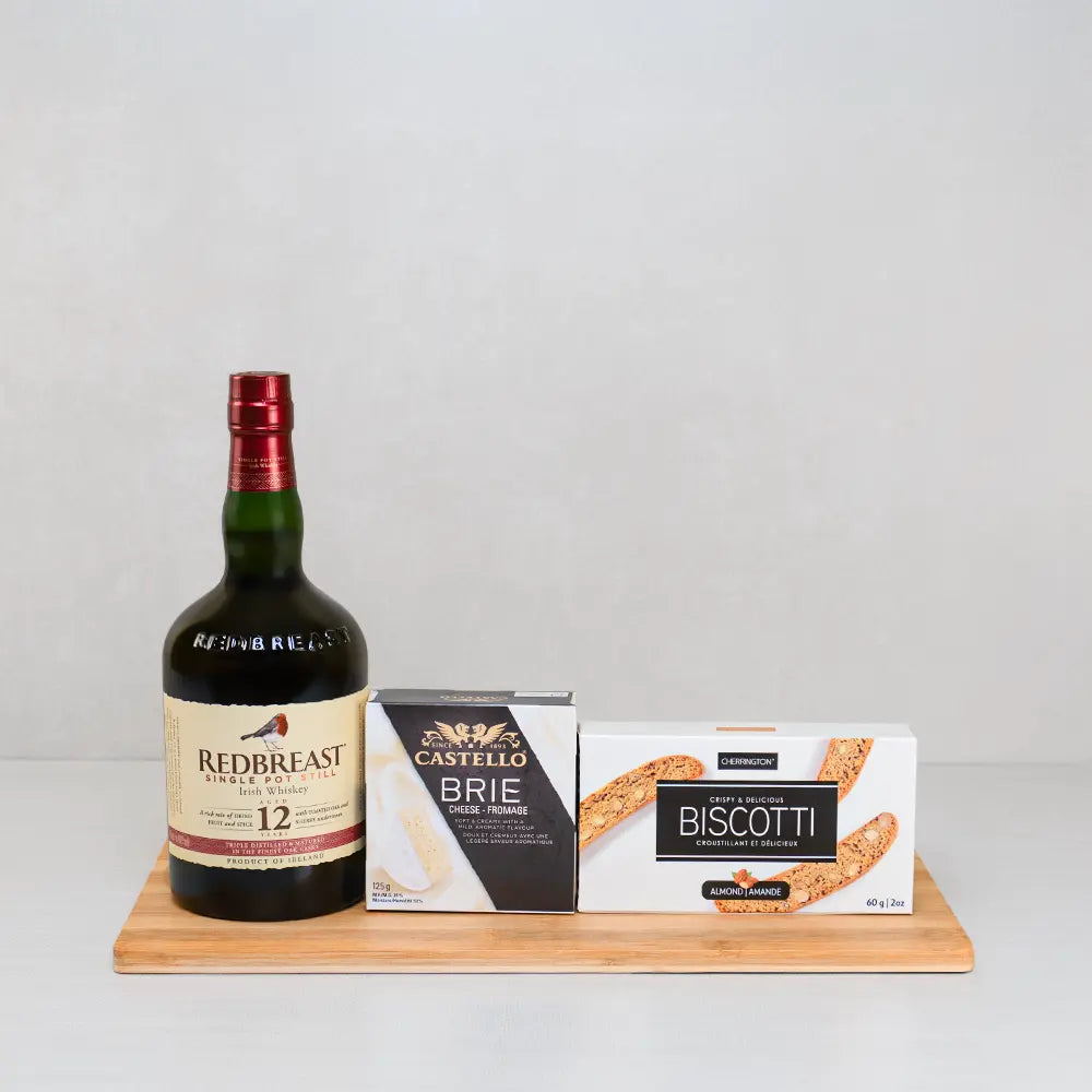 Whiskey Night Set with Redbreast 12 Irish whiskey, Castello brie and Cherrington almond biscotti lined up on a bamboo board