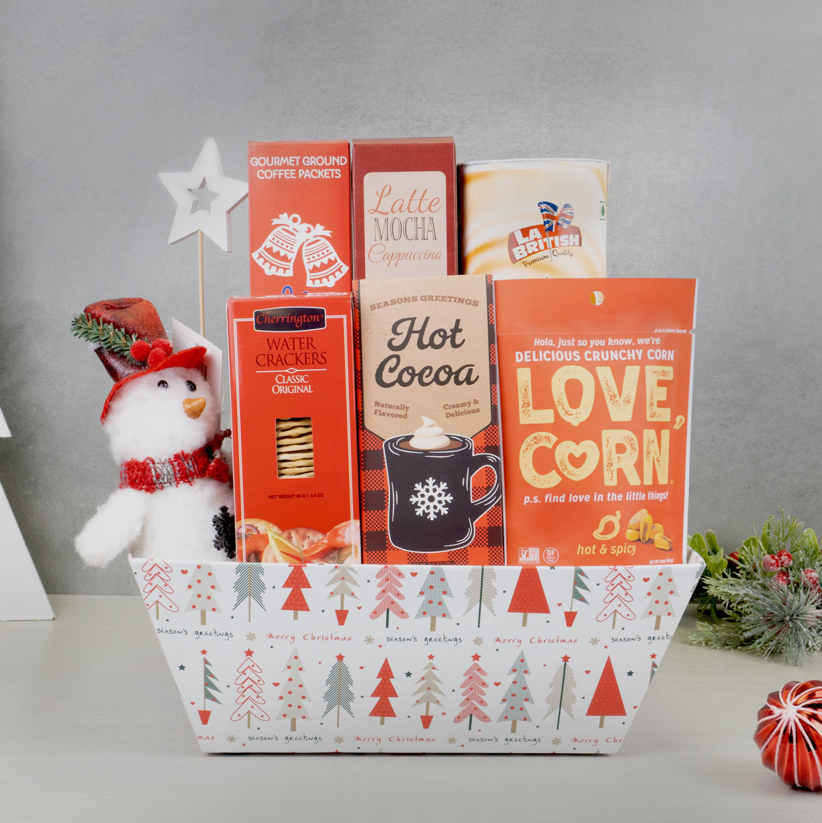 Christmas Cozy Cocoa & Coffee Basket with hot cocoa, coffee, latte mix, Love Corn and a snowman plush in a tree-print box