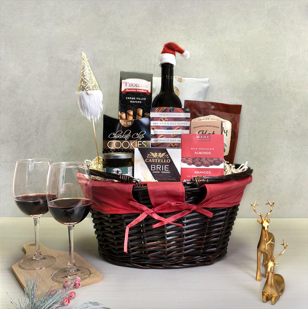 Classic Christmas Gift Basket with red wine in a Santa hat, a gnome pick, Castello brie, Pirouline wafers and Made almonds