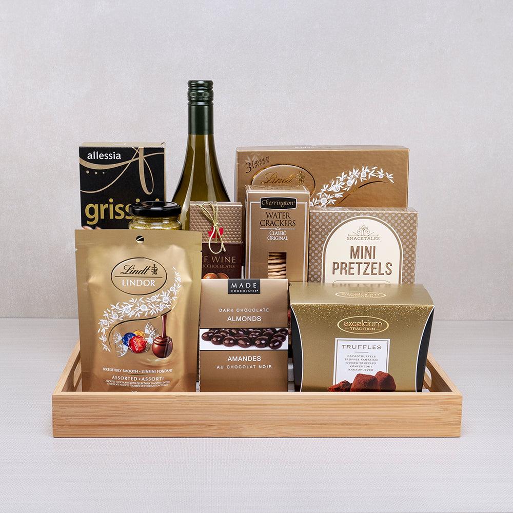The Luxe Golden Chocolate Collection with white wine, Lindt Lindor, Excelcium truffles and chocolate almonds on a bamboo tray